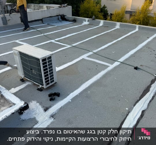 אדם עובד על איטום גג עם חומרי איטום לבנים.